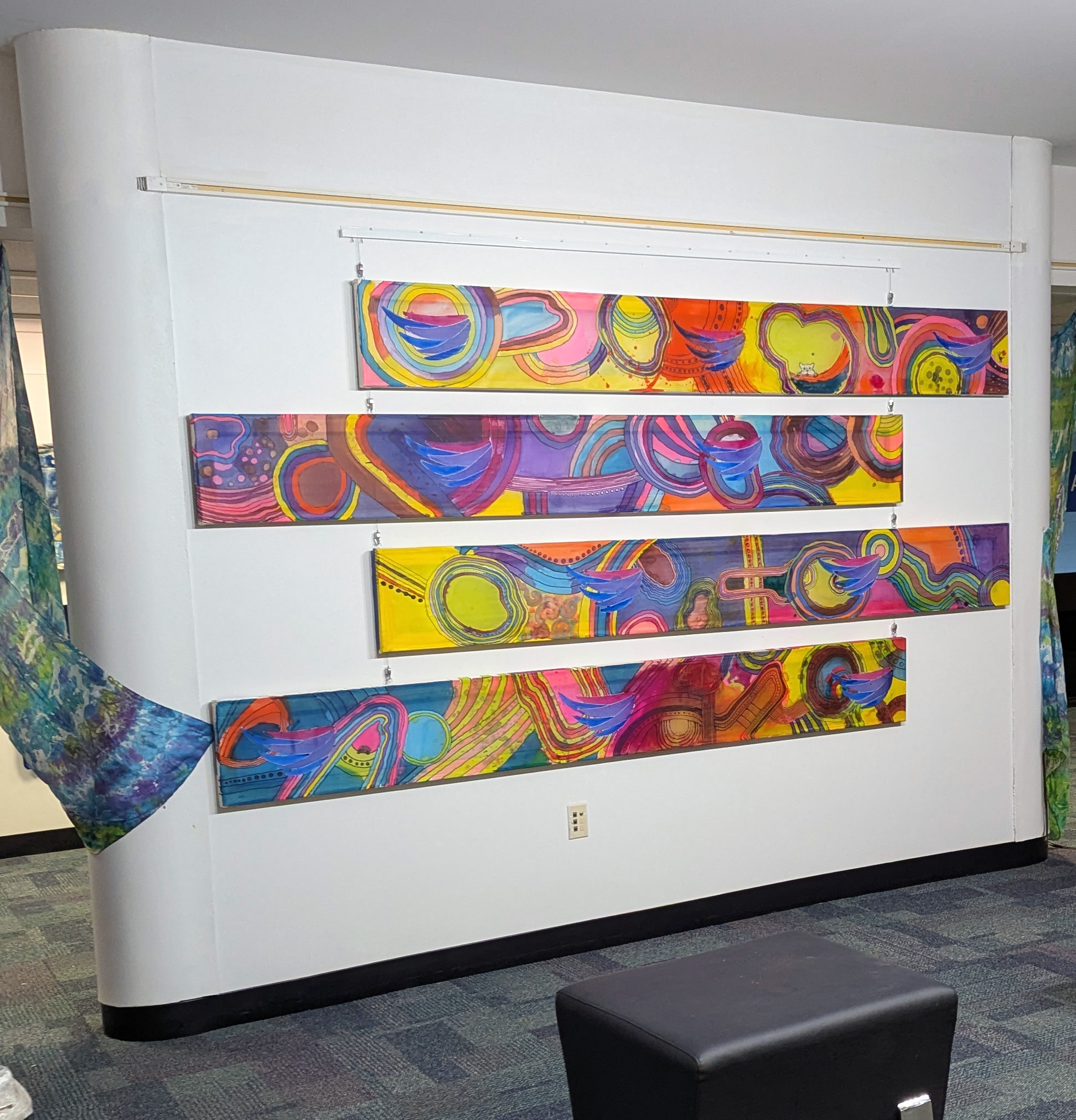 Four one foot by eight foot silk canvases with the ABLE NH logo interspersed. Colorful.