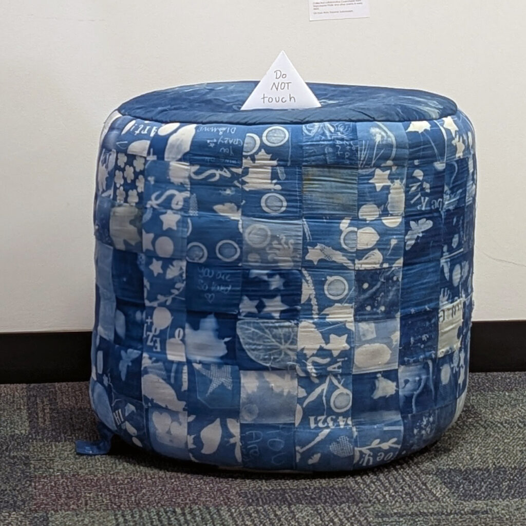 a blue cylinder meant for sitting, made of individual blue cyanotype squares