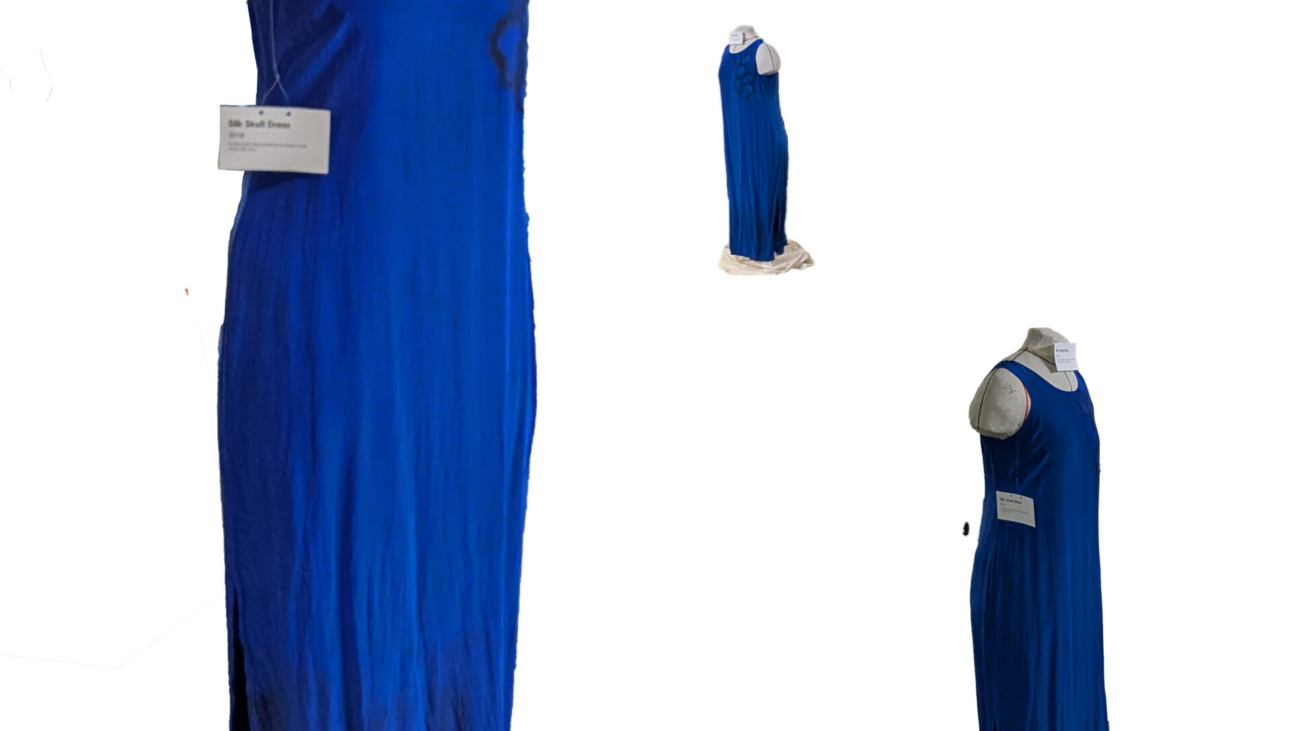 Three images of the same silk blue dress with a few skulls outlined in black on the left shoulder.