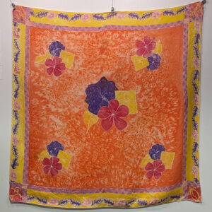 A large mostly orange silk scarf with hibiscus and Hawaiian glyphs.