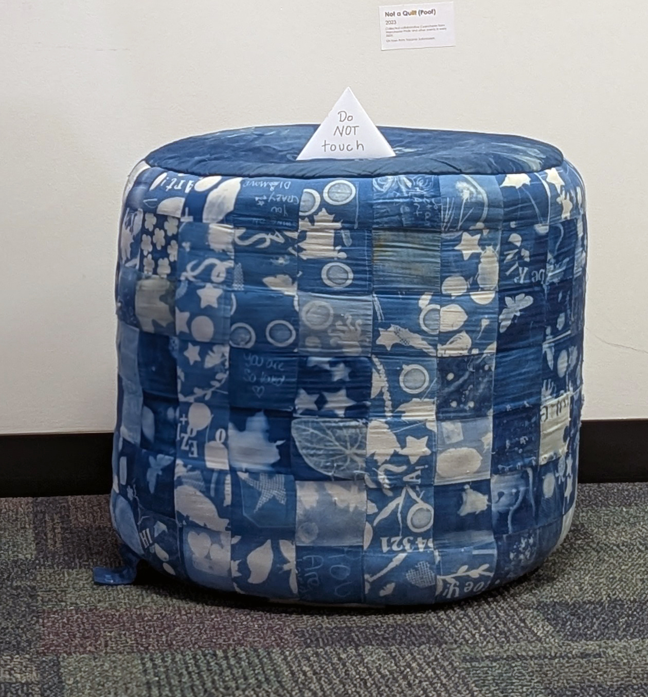 a blue cylinder meant for sitting, made of individual blue cyanotype squares